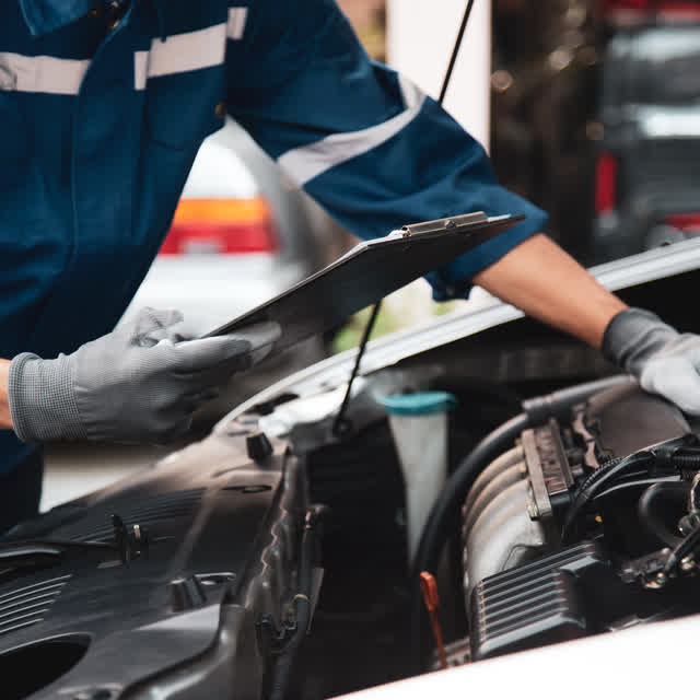 Mecánico de Talleres Bao - Dacal revisando el motor de un coche en su taller de Oleiros